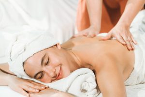 Attractive caucasian woman having back massage by masseur. Closeup. Tranquility.